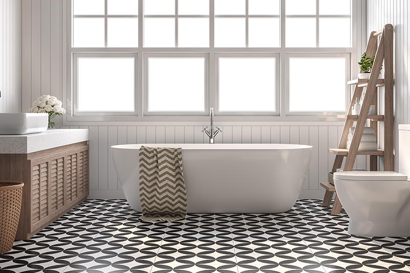 Modernes Badezimmer mit freistehender Badewanne, schwarzem Muster-Fliesenboden, großer Fensterfront und hellen Holzmöbeln.
